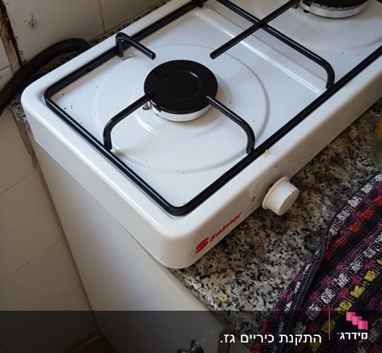 כיריים גז לבנים עם שני מבערים על משטח גרניט